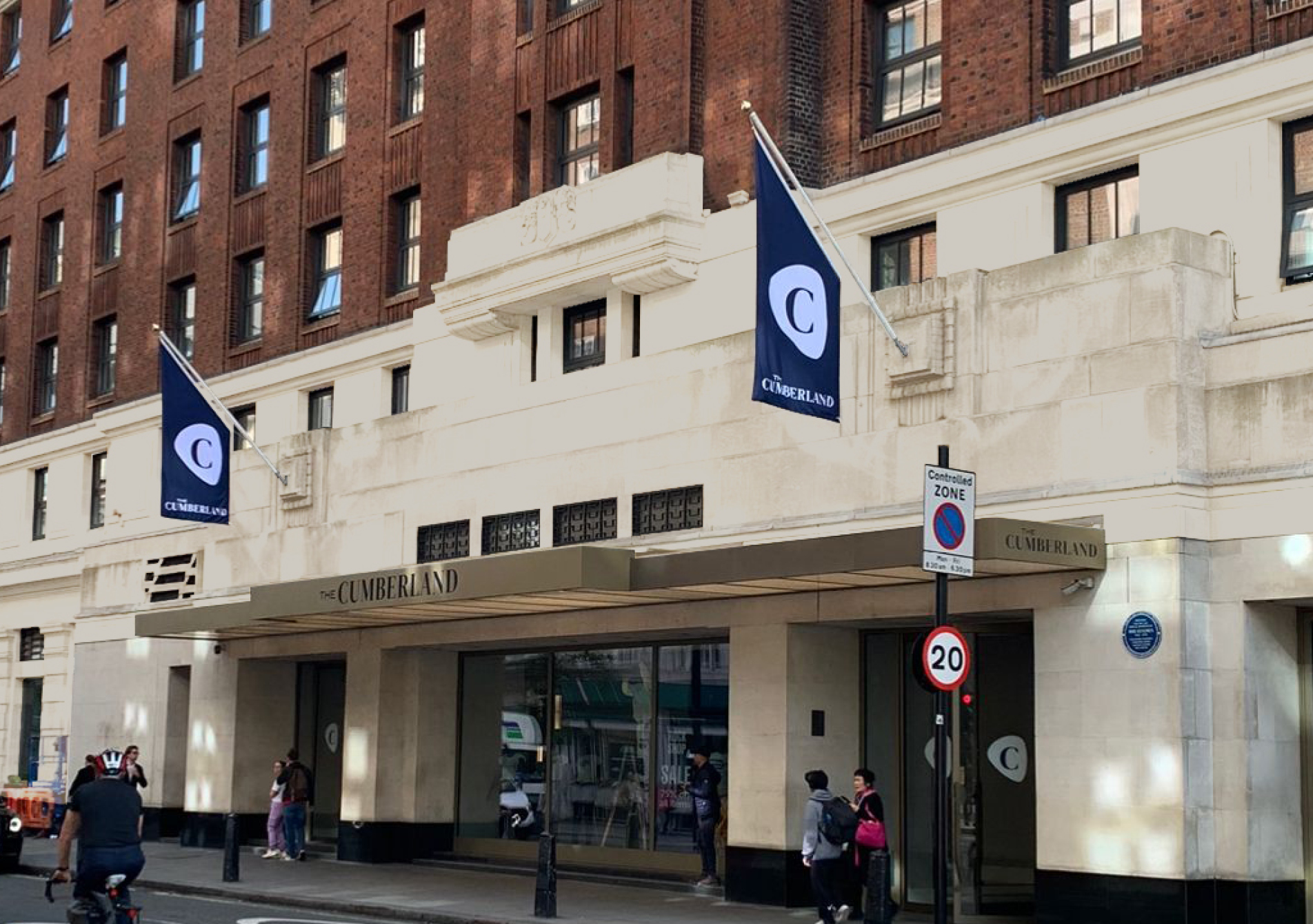 Exterior view of The Cumberland hotel with a branded flag hanging above the door