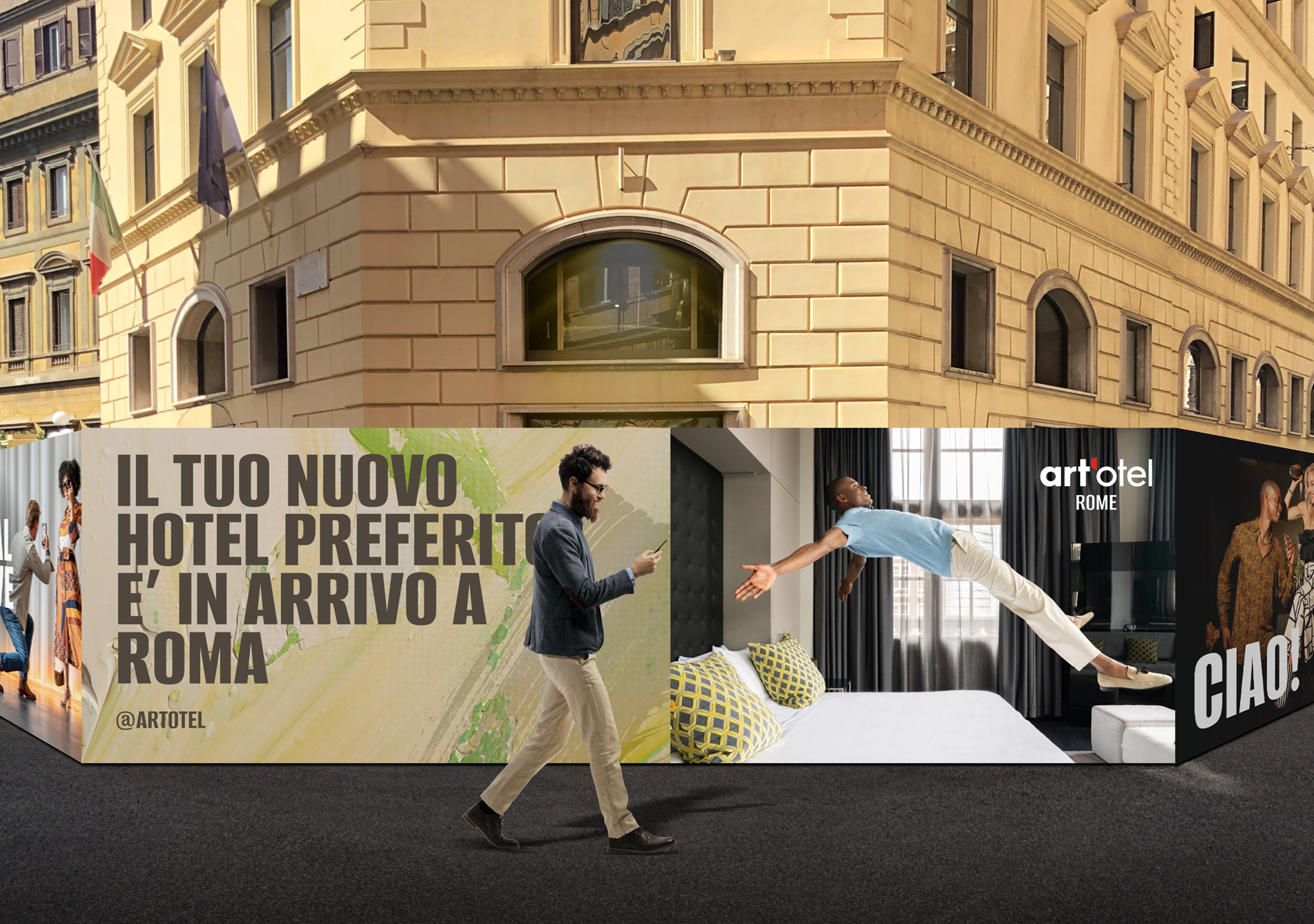 Man holding phone walking in front of hoarding with art'otel creative branding