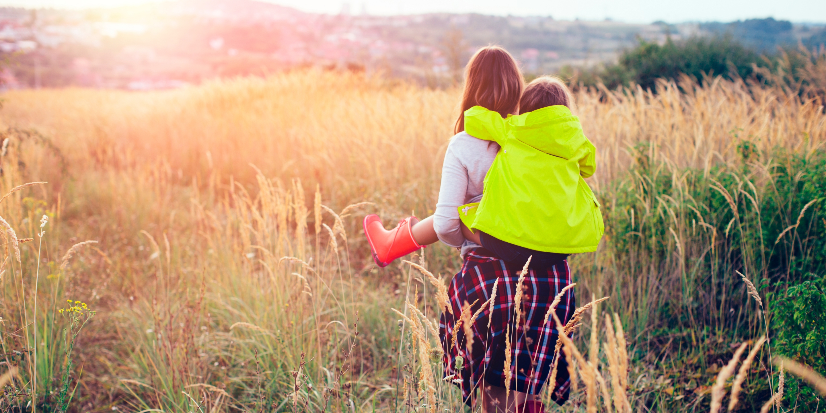Woman and a child on a bicycle in a field of wheat