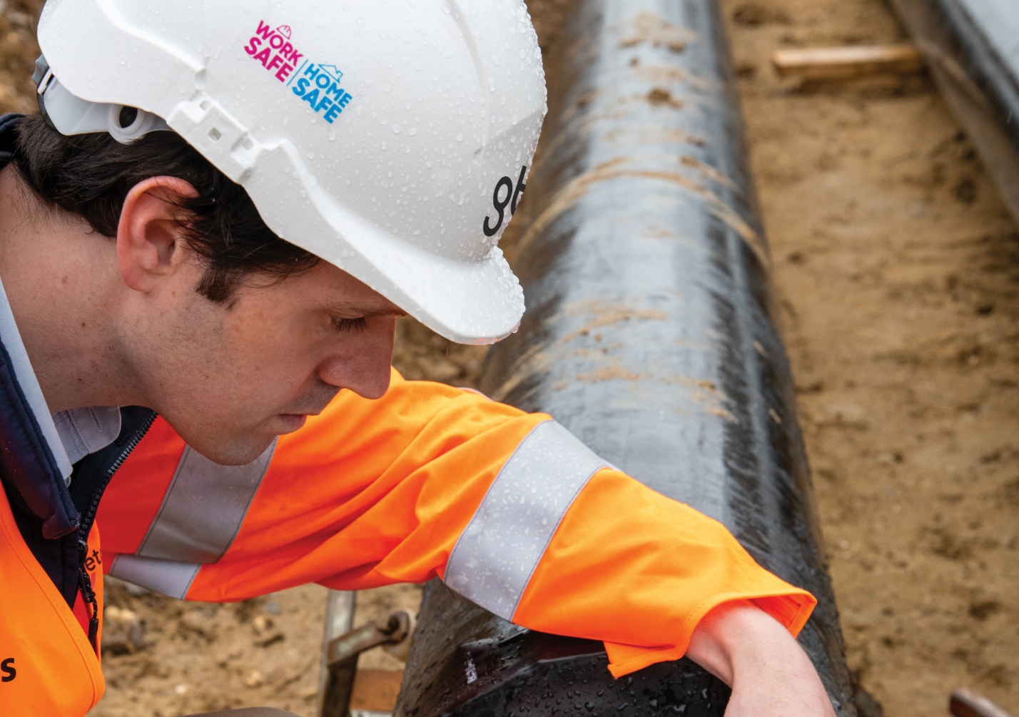 Workman in a high-vis jacket inspecting pipework