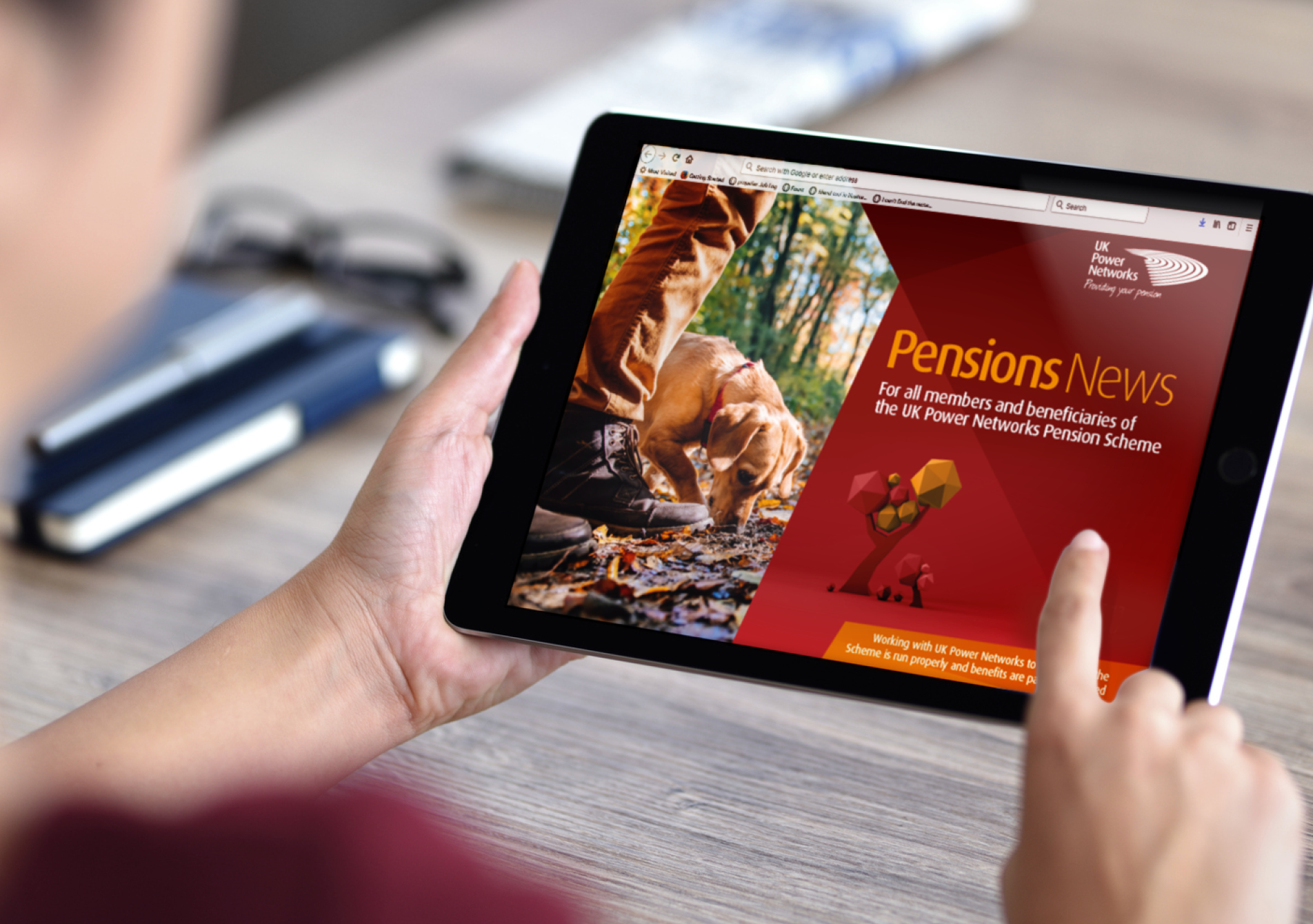 Person holding iPad scroll through digital version of UK Power Networks Pension News booklet
